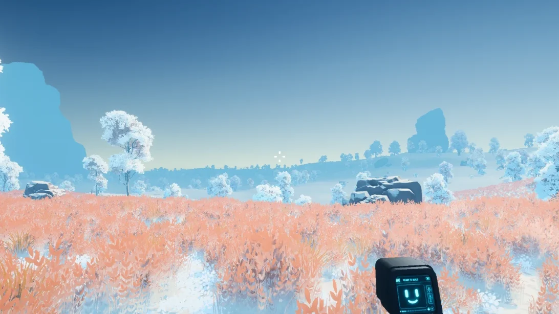 A field of rust-orange grass running to the sea, dotted with frost-white trees under a clear sky.